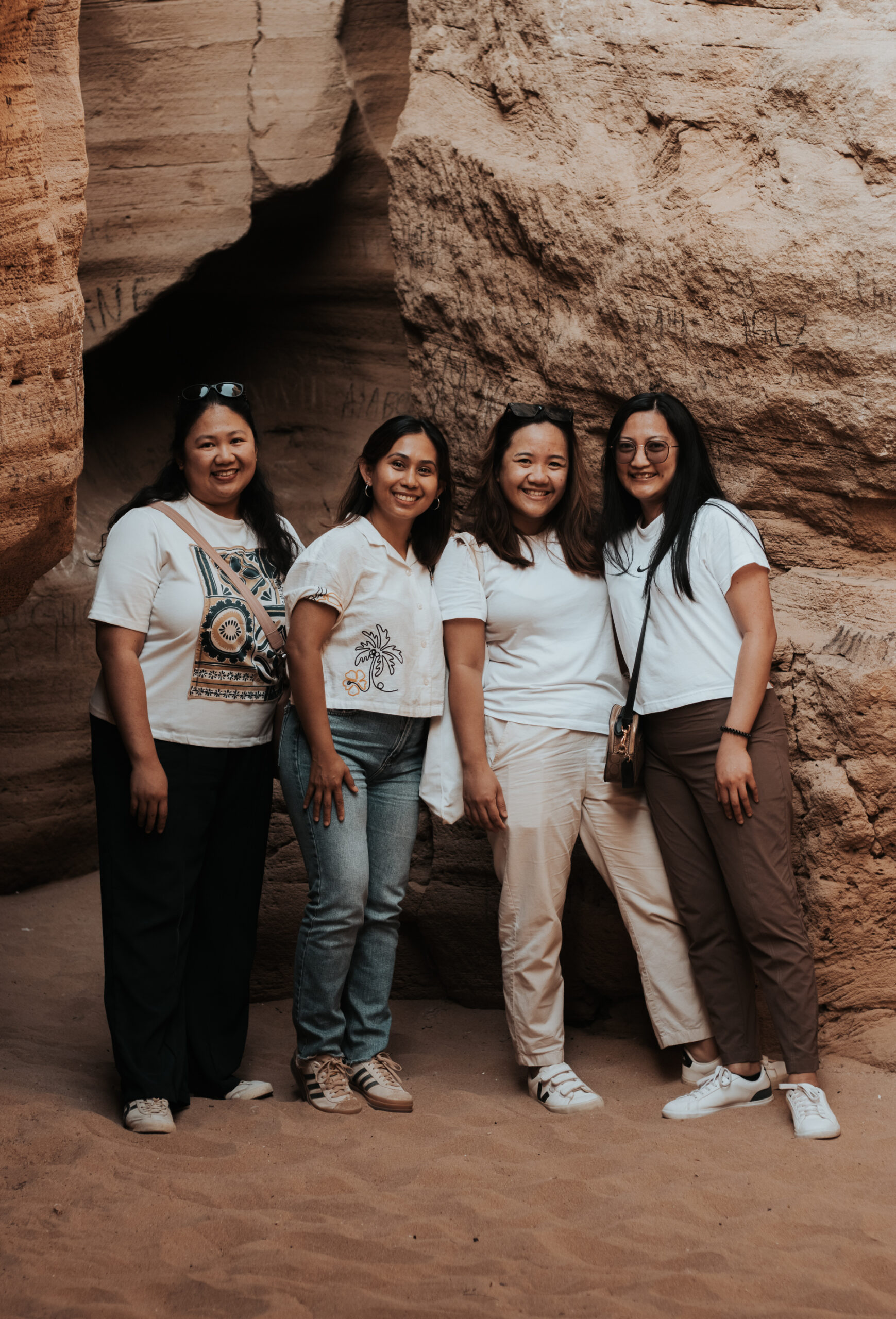 Group of girls exploring the Timlalin coastal caves during a sandboarding trip near Agadir"