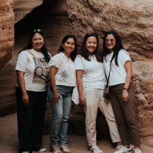 Group of girls exploring the Timlalin coastal caves during a sandboarding trip near Agadir"